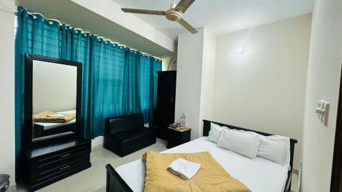 a bedroom with a bed and a mirror and a chair at Hotel Olio Dream Heaven in Dhaka