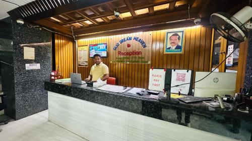 a man standing behind a counter in a restaurant at Hotel Olio Dream Heaven in Dhaka