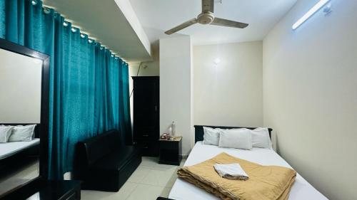 a bedroom with a bed and a black chair at Hotel Olio Dream Heaven in Dhaka
