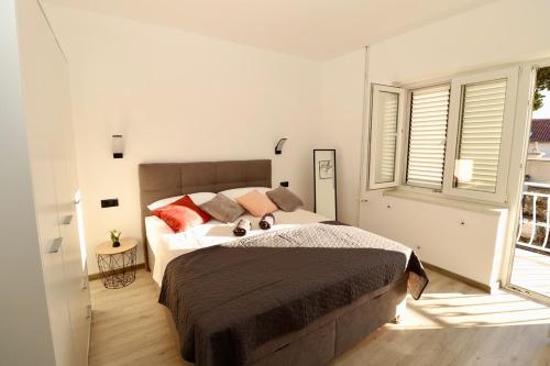 a bedroom with a large bed and a window at Fidelis Apartment - Walk to the Beach in Minutes in Novi Vinodolski