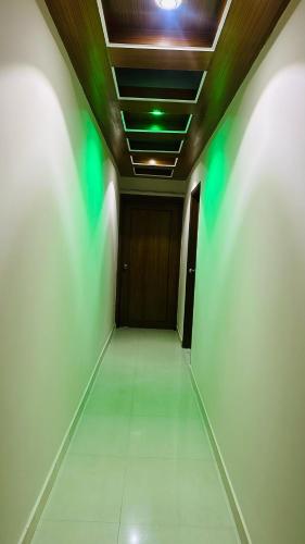 an empty hallway with a door and green lights at Hotel Olio Dream Heaven in Dhaka