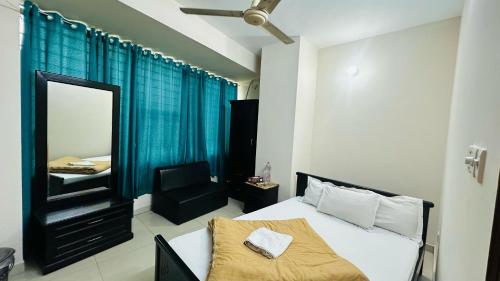 a bedroom with a bed and a mirror and a chair at Hotel Olio Dream Heaven in Dhaka