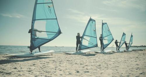 a group of people on the beach with sailboats at Apple Blossom Studio - near Rønne and Beach in Rønne