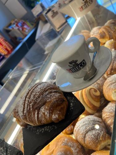 a display case in a bakery with a cup of coffee and pastries at Villa Vera in Salerno