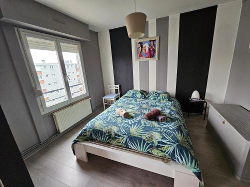 une chambre avec un lit et une grande fenêtre dans l'établissement Appartement à proximité de la plage de Malo, à Dunkerque