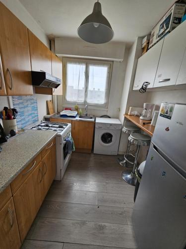 une cuisine avec un évier et une cuisinière four supérieur dans l'établissement Appartement à proximité de la plage de Malo, à Dunkerque