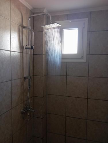 a shower with a window and a shower curtain at ARTEMIS beach studios in Kalamaki Heraklion