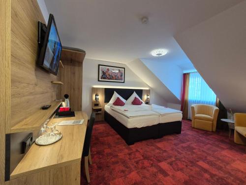 a hotel room with a bed and a desk at Hotel St. Georg Garni in Celle