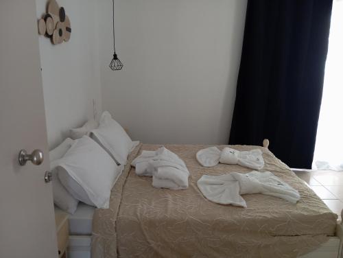 a bed with white towels on top of it at ARTEMIS beach studios in Kalamaki Heraklion