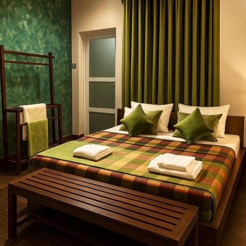 a bedroom with a large bed with green curtains at Stone Gate in Katugastota