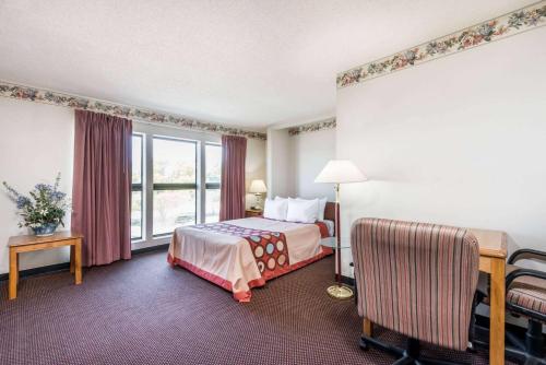 a hotel room with a bed and a window at Super 8 by Wyndham Du Quoin in Du Quoin