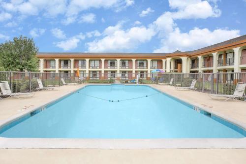 a large swimming pool in front of a building at Days Inn by Wyndham Ruther Glen Kings Dominion Area in Ruther Glen