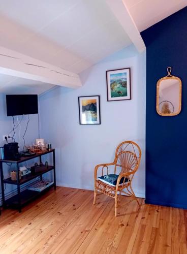 a room with a chair and a blue wall at Au bord de l'eau Salles sur Cerou in Salles