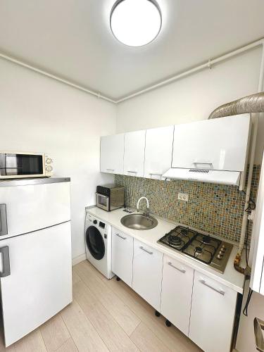 a kitchen with a sink and a washing machine at Summerland Seaview Apartments in Mamaia