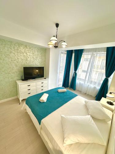a bedroom with a large bed and a television at Summerland Seaview Apartments in Mamaia