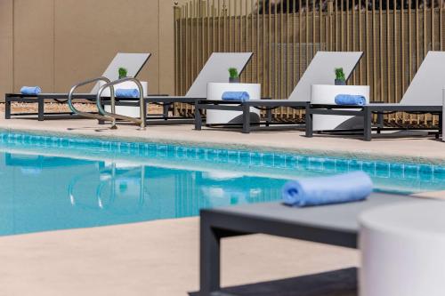 a row of lounge chairs next to a swimming pool at DoubleTree by Hilton Las Vegas Airport in Las Vegas