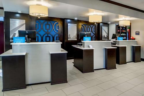 a lobby with a row of counters with computers at Embassy Suites by Hilton St Louis Airport in Bridgeton