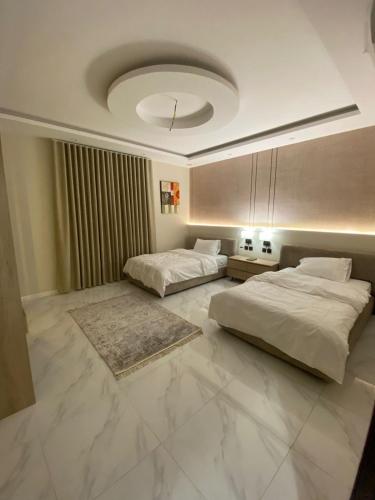 a bedroom with two beds and a ceiling at منزال in Al Madinah