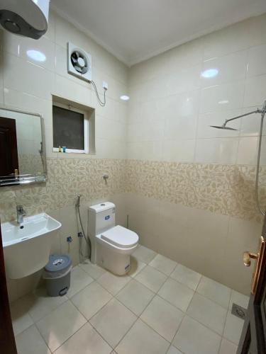 a bathroom with a toilet and a sink at منزال in Al Madinah