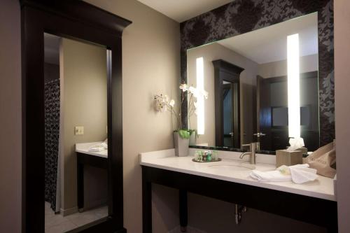 a bathroom with a sink and a large mirror at The Giacomo, an Ascend Collection Hotel in Niagara Falls