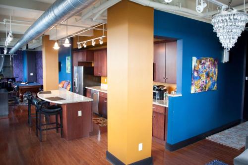 a kitchen with blue and yellow walls and a island at The Giacomo, an Ascend Collection Hotel in Niagara Falls