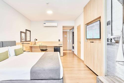 a bedroom with a large bed with a tv on a wall at Dazzler by Wyndham Rosario in Rosario