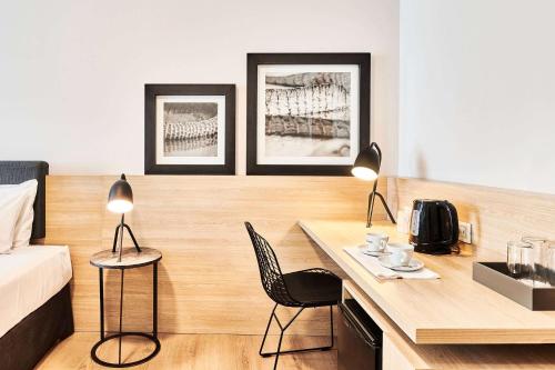 a room with a desk with two chairs and a bed at Dazzler by Wyndham Rosario in Rosario
