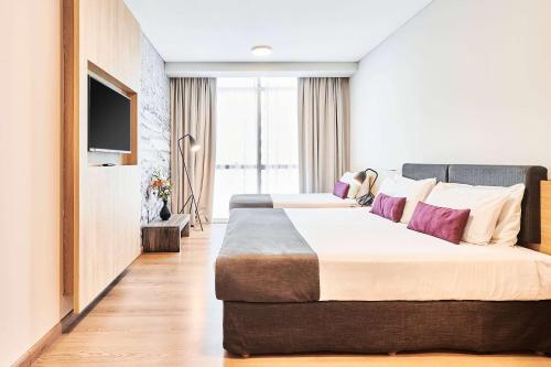 a hotel room with two beds and a flat screen tv at Dazzler by Wyndham Rosario in Rosario