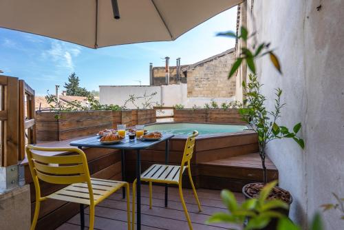 un patio avec une table et des chaises et une piscine dans l'établissement Le perchoir du Saint-Didier, à Avignon