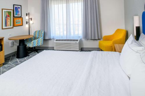 a hotel room with a bed and a table and a chair at Hampton Inn By Hilton St Louis Airport in Saint Louis
