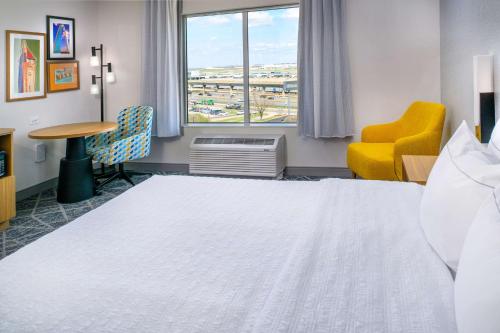 a hotel room with a bed and a desk and a window at Hampton Inn By Hilton St Louis Airport in Saint Louis