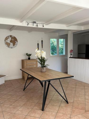 un salon avec une table avec des fleurs dessus dans l'établissement Villa maison individuelle avec jardin arboré, aux Vans