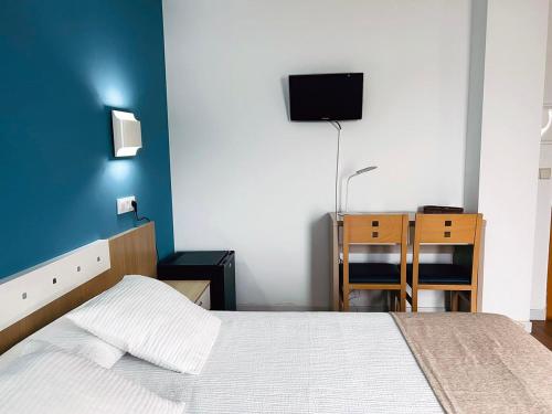a bedroom with a bed and a desk and a tv at La Cabaña in Peñíscola
