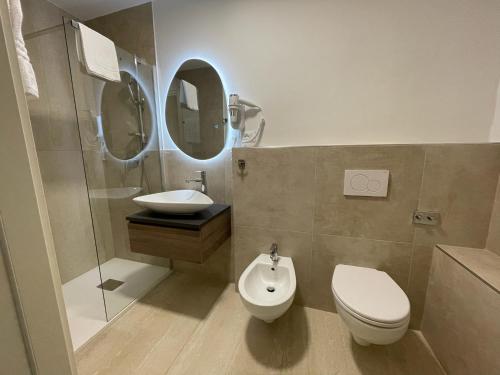 a bathroom with a toilet and a sink and a mirror at Il Genio - Residenza D'Epoca in Pisa