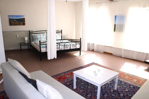 ein Wohnzimmer mit einer Couch und einem Bett in der Unterkunft Ferienwohnung Altes Pfarrhaus mit Flair und Moselblick in Brauneberg