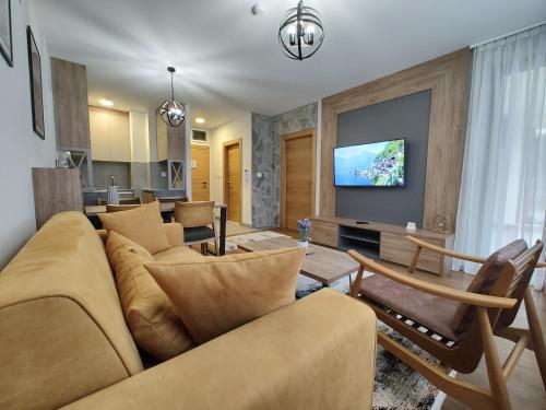 a living room with a couch and a tv at Apartmani Trg Zlatibor in Zlatibor