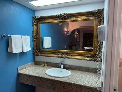 a bathroom with a mirror and a sink at El Dorado Motel in Gardena