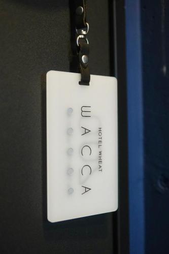 ToyohiraにあるHotel Wheat Waccaの白いリモコンがドアに掛けられている