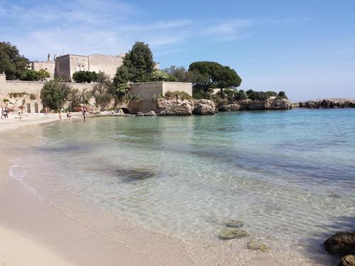 ein Strand mit Menschen, die auf dem Sand und dem Wasser spazieren in der Unterkunft Dimora Del Sorriso in Monopoli