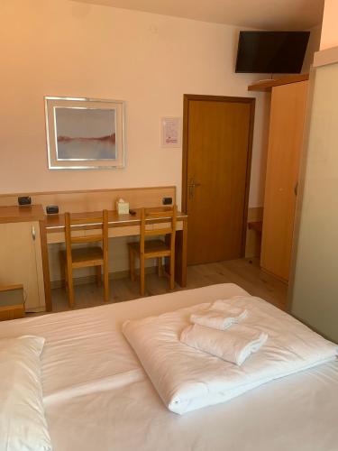 a bedroom with a bed and a table and a desk at Hotel Garnì Delle Rose in Dro