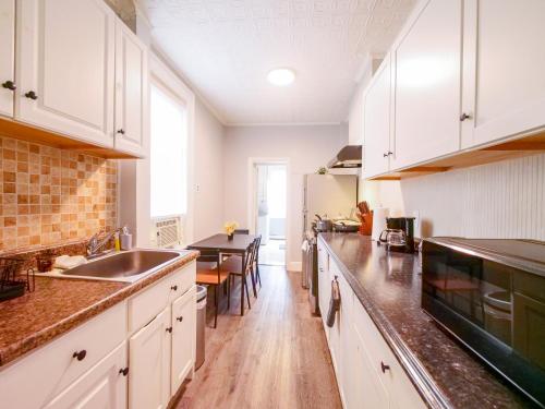 a kitchen with white cabinets and a dining table at Serene Two-Bedroom Retreat - close to NYC in Jersey City