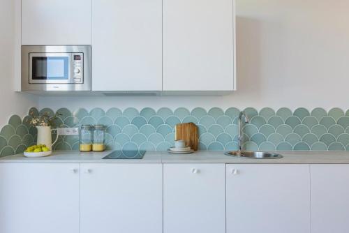 a kitchen with a sink and a microwave at Exclusive beachfront apartment in Valencia