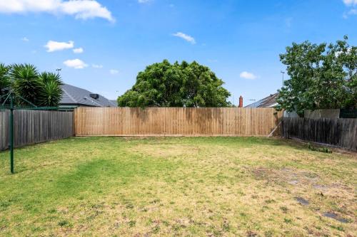 a backyard with a wooden fence and a yard at Bonbeach Beauty Relaxation Haven in Bonbeach in Bonbeach