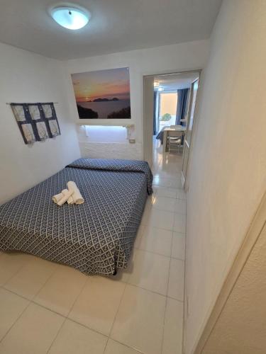 a bedroom with a bed with a pair of shoes on it at Agenzia Aprea Appartamenti in Ponza