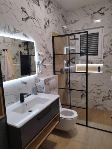 a bathroom with a white sink and a toilet at Robinzon kuća Niko in Zadar