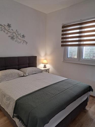 a bedroom with a large bed and two windows at Robinzon kuća Niko in Zadar