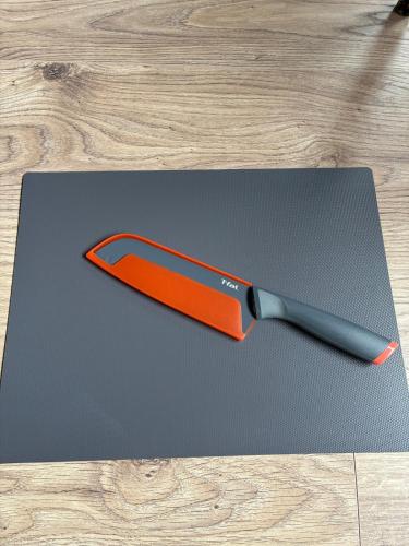 an orange knife sitting on top of a cutting board at NagataSeaTime in Yakushima