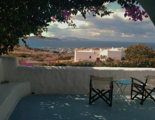 two chairs and a table on a balcony with a view at Λιογερμα in Koufonisia