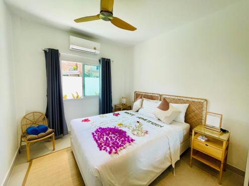 a bedroom with a large bed with purple flowers on it at Baan Saint-Tropez Seaview Villas Kata Beach in Kata Beach