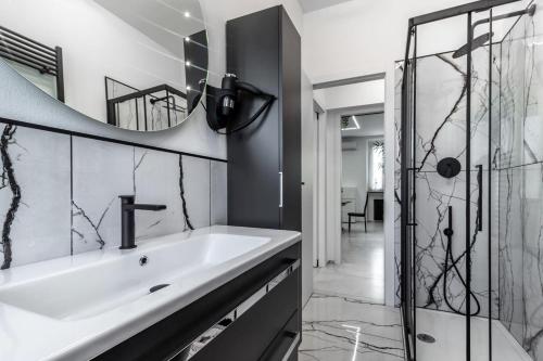 a bathroom with a sink and a shower at Black & White Apartment Design e Comfort - Parking e WiFi in Saronno